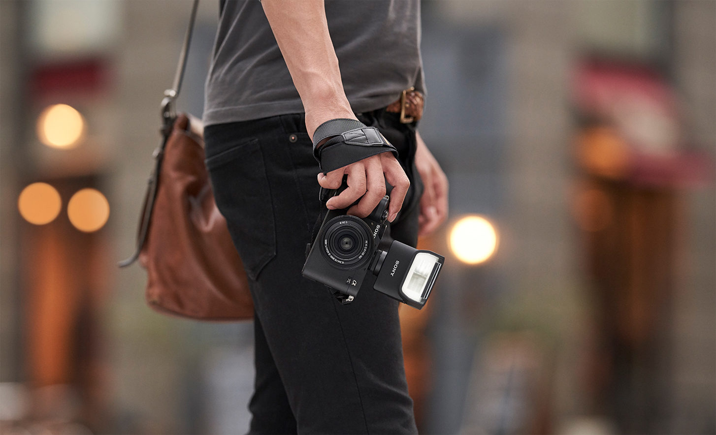 Käyttökuva henkilöstä, joka pitelee kameraa, johon on kiinnitetty salama